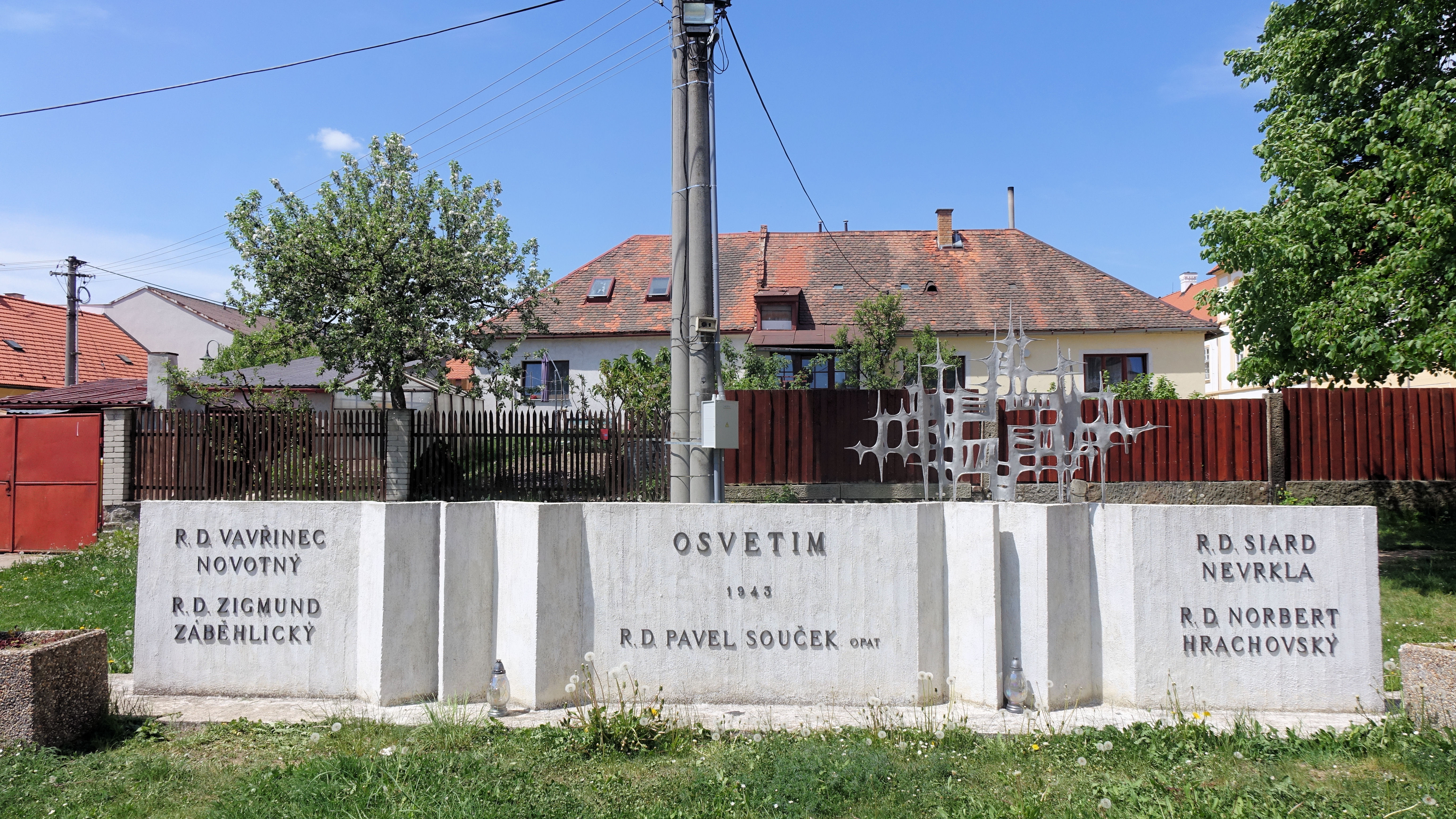 Pomník umučených v Osvětimi před kostelem a před klášterem v Nové Říši